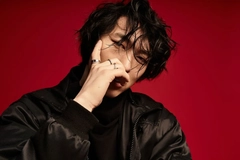 Korean man against a red backdrop with black clothing