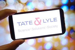 A hand holding a phone that says Tate & Lyle on it.