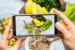 Person using mobile phone to take a picture of food.