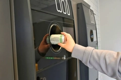 Image A hand putting a can into a recycling bin.