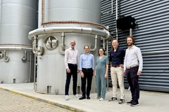 people near bioreactor people standing in front of large bioreactor