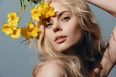 A woman holding yellow flowers in front of her hair
