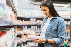young woman in supermarket holding two bottles young woman in supermarket holding two bottles