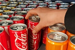 Image A hand reaching for a can of soda