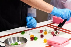 colorful candies and hands in blue gloves