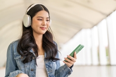 Gen Z girl listening to something on headphones