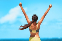 Goal achievement happy woman with open arms outdoors in success