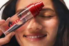 Image Woman holding the olaplex fragrance mist in front of her face