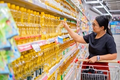 Image Woman shopping for vegetable oil in the supermarket.