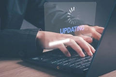 Image A person typing on a computer that is updating