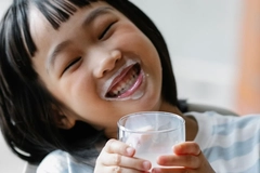 Image Young Asian girl drinking yogurt