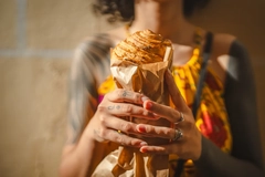 Image Woman holding pastry wrapped in brown paper