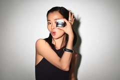 Image Woman playfully holding up a Neutrogena skin cream in front of her face