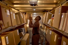 Image A person looking at boxes in a warehouse