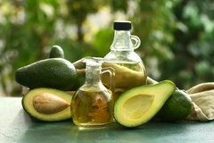 Image Avocados and avocado oil on an outdoor table.