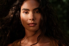 Image Woman with dark hair standing in natural environment
