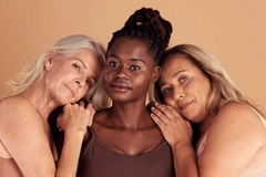 Three older woman together hugging.