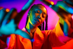 Image Woman in neon lighting pointing her hands out