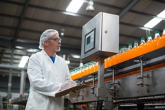 Food scientist monitoring orange juice on the production line.